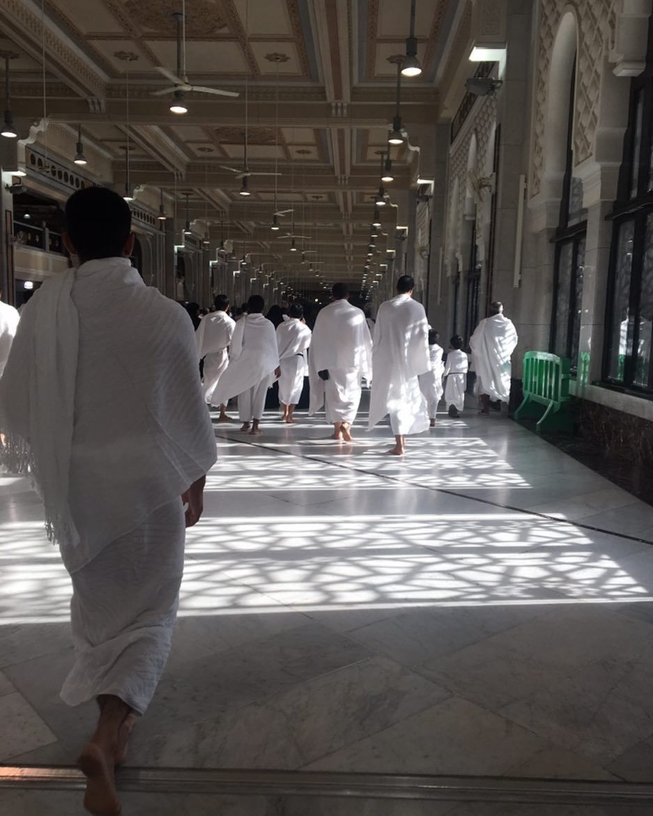 Pilgrims walking through a colonnade of the Haram